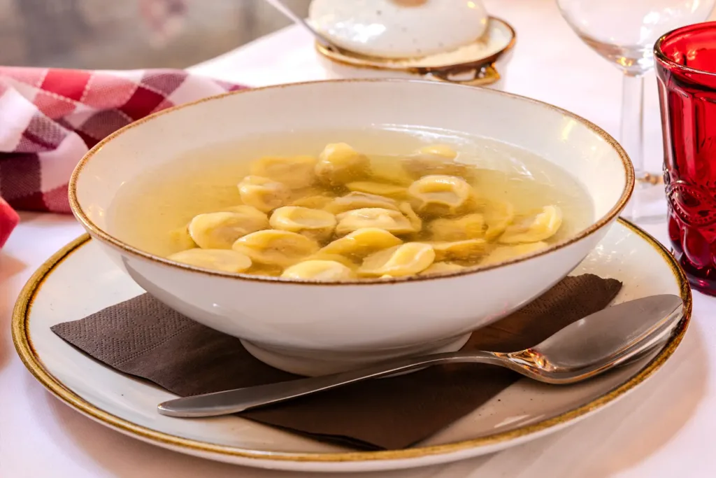 Cappelletti di pasta fresca serviti in brodo caldo alla Trattoria Corrieri, piatto tipico della cucina parmigiana