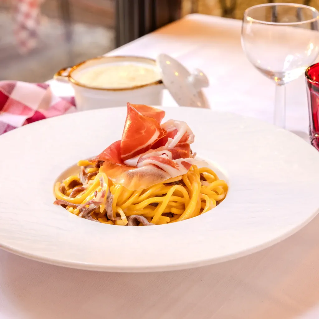 Tagliolini freschi fatti a mano conditi con culatello, serviti alla Trattoria Corrieri di Parma.